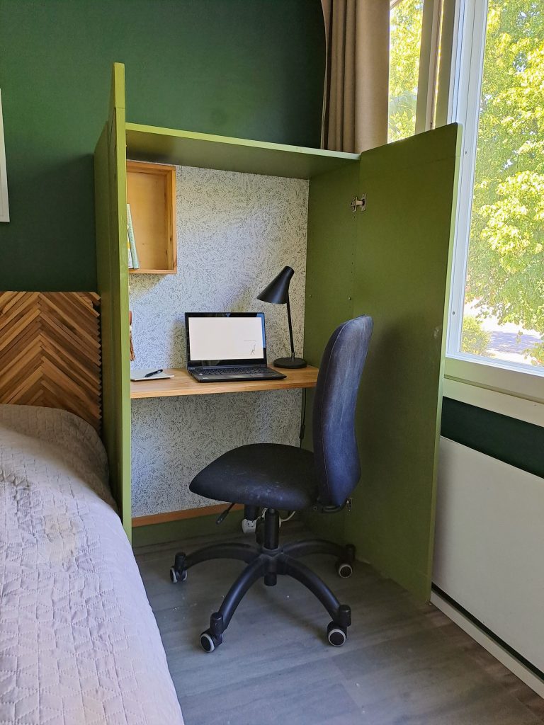 työtila kaapissa, ovet avattuna. työtuoli kaapissa, samoin läppäri